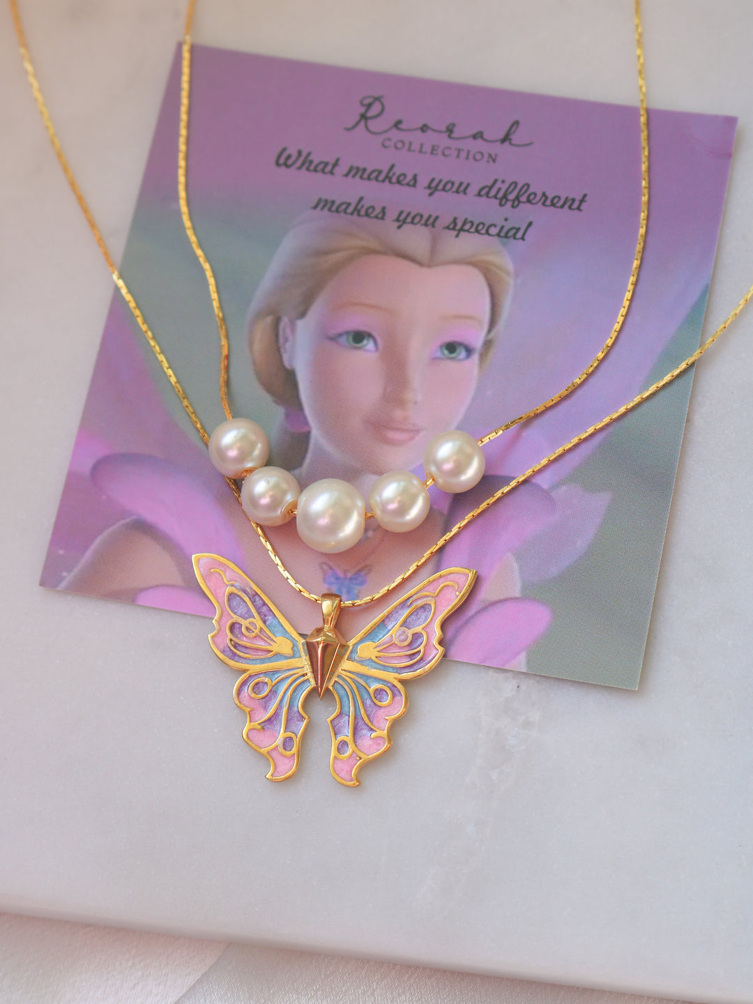 Butterfly necklace with pearl pendant on a branded card