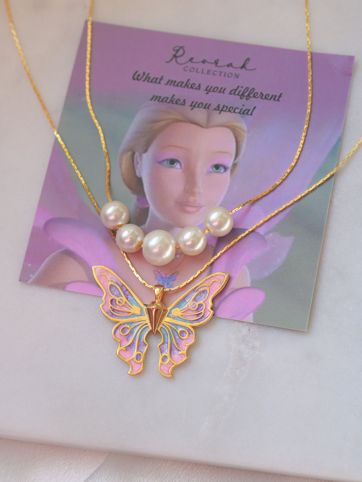 Butterfly necklace with pearl pendant on a branded card