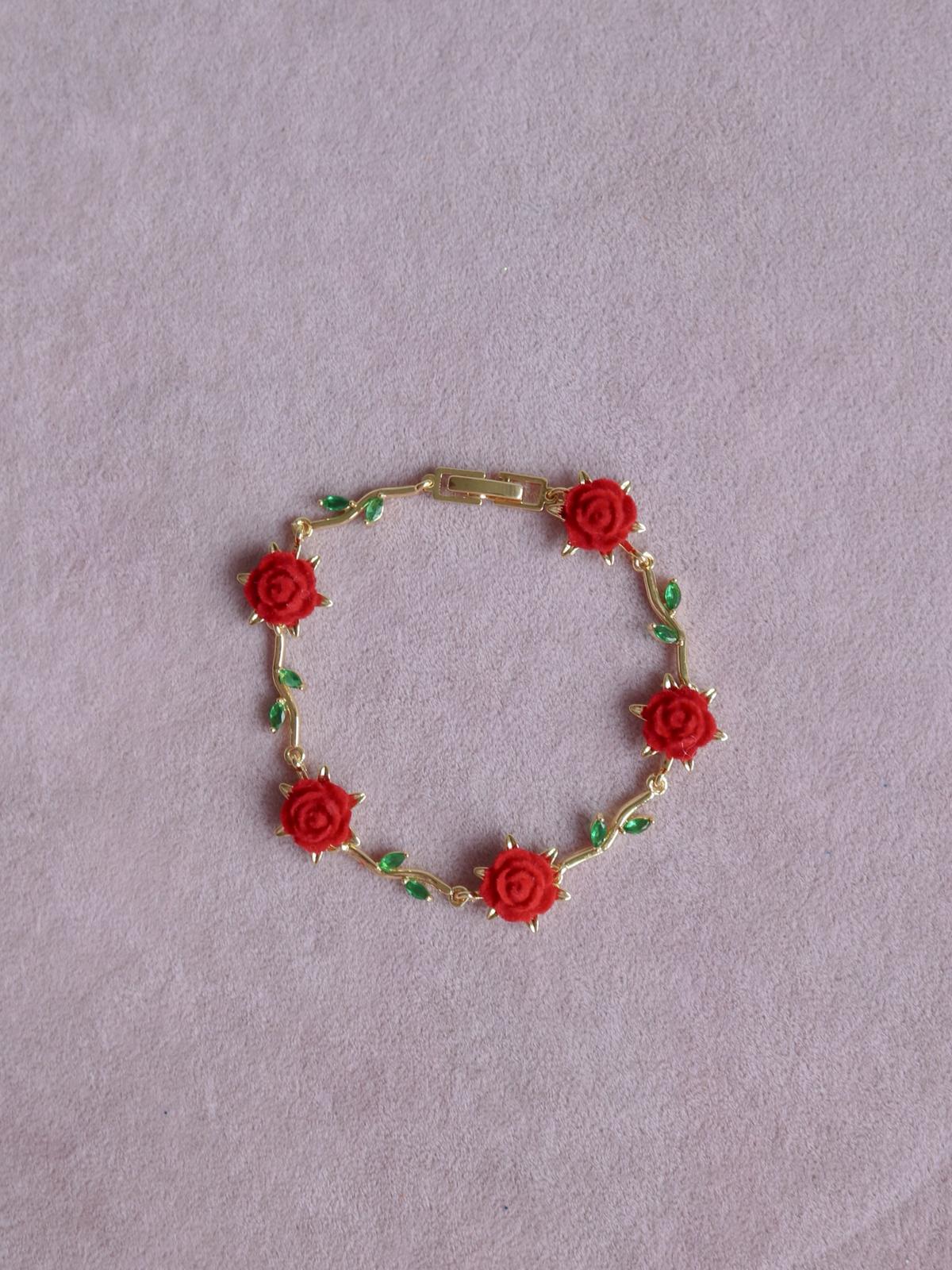 Belle La Vie En Rose Bracelet with red rose decorations on a light purple background